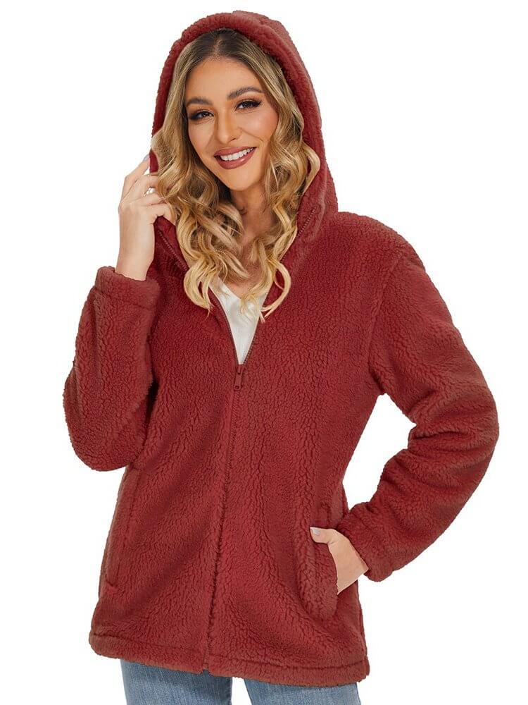 Woman wearing a stylish fluffy red jacket with hood and zipper closure, showcasing cozy fashion and functionality for colder days.
